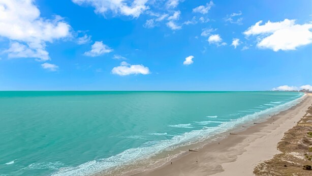 A beach with clear turquoise water and a sandy shore. - Crescent Shores 1806 - Oceanfront condo rental  (North Myrtle Beach)