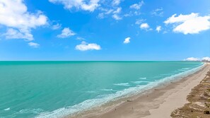 A beach with clear turquoise water and a sandy shore.