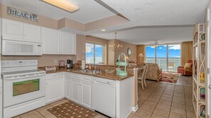 Enjoy a well-appointed kitchen and living area with a sofa set, dining table, and microwave.