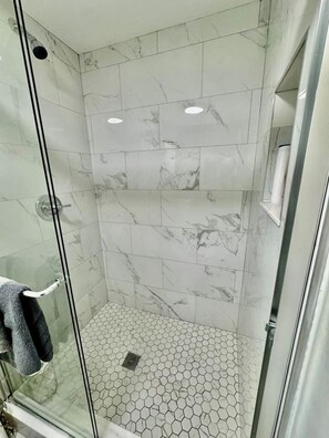 Chuveiro, secador de cabelo, toalhas de banho, shampoo