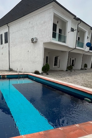 A residential building with a swimming pool, a covered patio, and a satellite dish. - A stunning 4 bedroom terrace in the heart of Lekki. 15 mins drive to all u need. (Lekki)