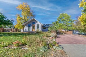 A single-story house with a front yard, a driveway, and a fenced backyard.