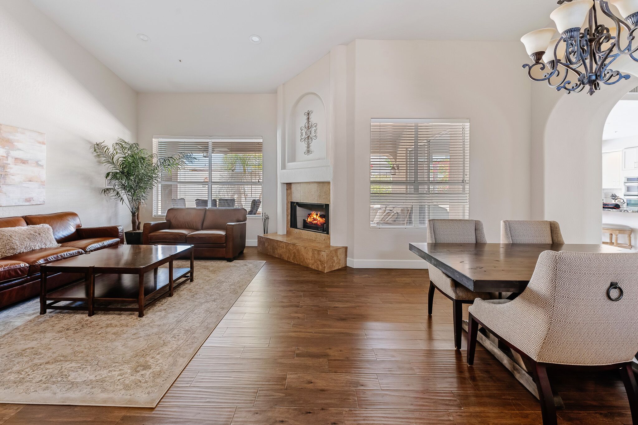 A spacious living room with a fireplace, a dining area, and a seating arrangement.