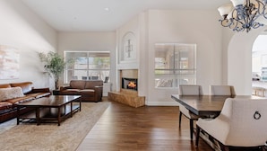 A spacious living room with a fireplace, a dining area, and a seating arrangement.