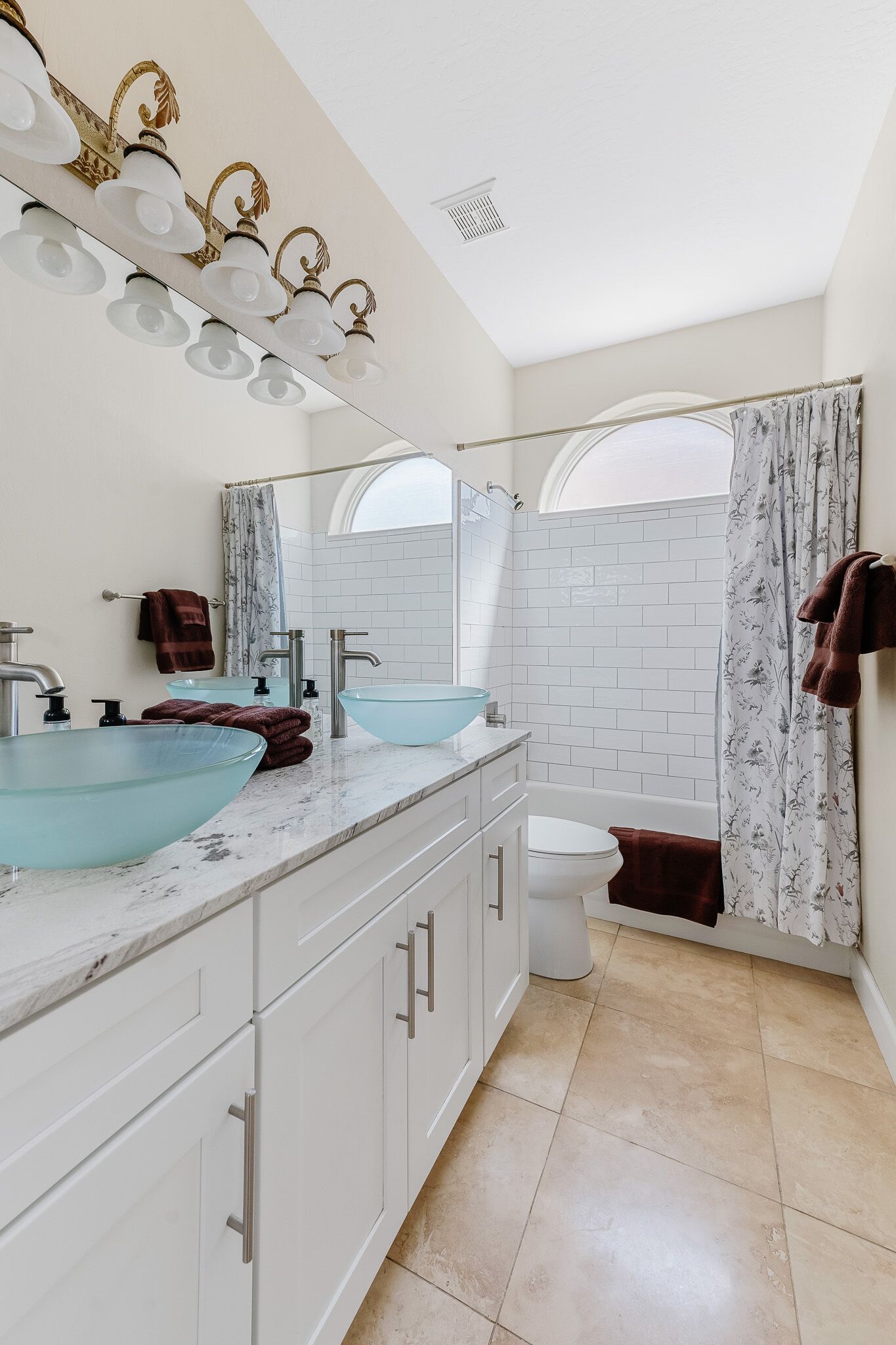 A bathroom with two sinks, a toilet, and a shower.