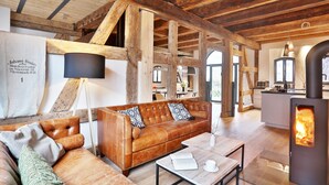 Ein gemütliches Wohnzimmer mit Ledersofa, Couchtisch und Kaminofen.