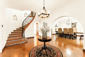 A spacious interior with a wooden staircase, a dining area with a round table, and a chandelier. - Casa Canasa in charming San Antonio!!!! Must see!!! (San Antonio)