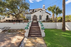 A building with a staircase leading to a door, surrounded by a white wall and greenery. - Casa Canasa in charming San Antonio!!!! Must see!!! (San Antonio)