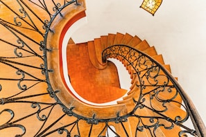 A spiral staircase with ornate metal railings and wooden steps. - Casa Canasa in charming San Antonio!!!! Must see!!! (San Antonio)