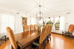 Comedor con mesa de madera, sillas estampadas y candelabro.