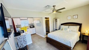 Une chambre à coucher avec un lit, une table de chevet et un ventilateur de plafond.