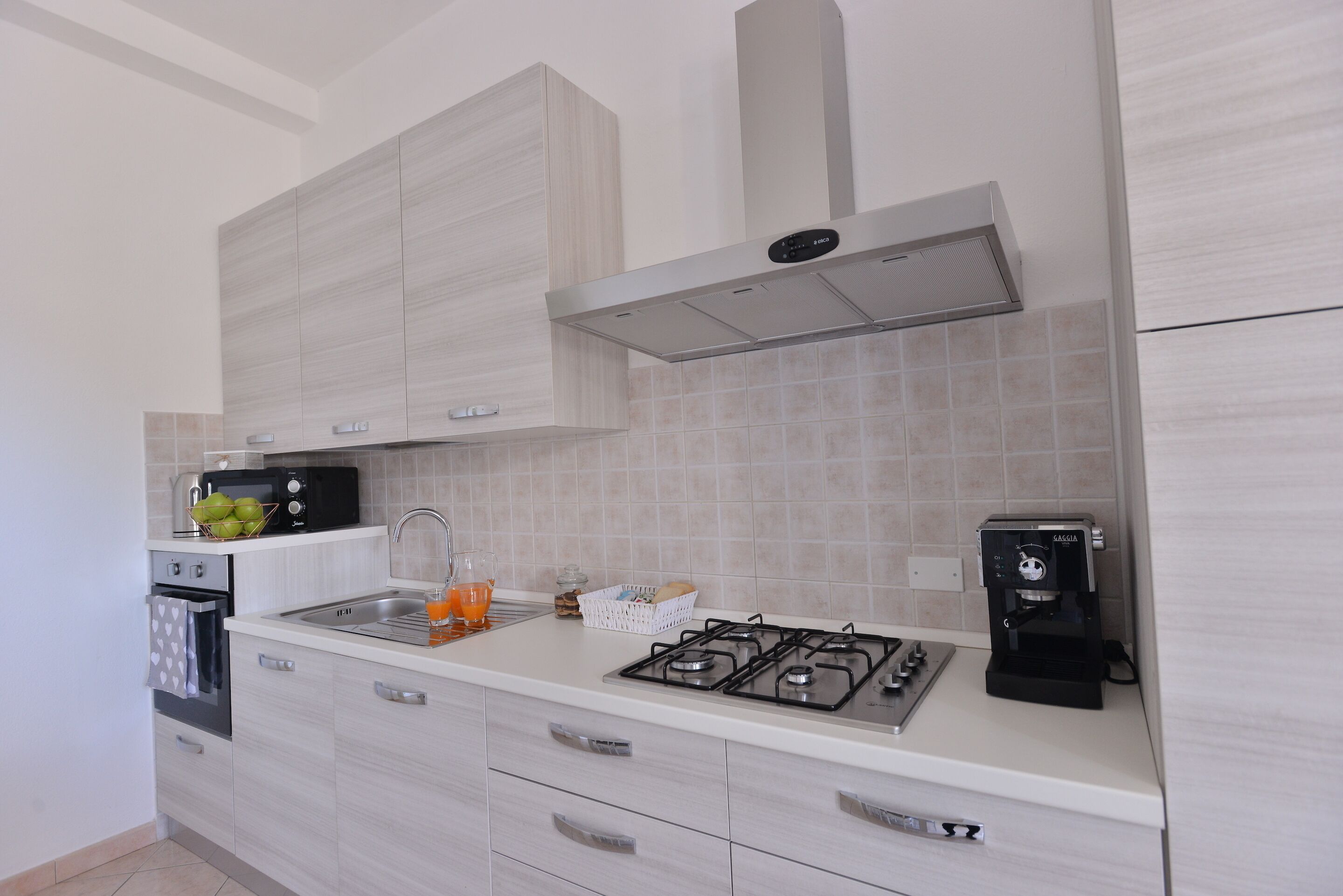 A modern kitchen with a gas stove, microwave, and coffee maker.