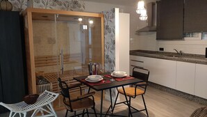 A modern kitchen with white cabinets, a wooden dining table, and a glass partition. - Sierra Lof Paradise Apartment (Ubrique)