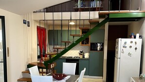A compact kitchen with a dining area, a staircase, and a refrigerator. - House Mary, 15 minutes from the splendid beaches of Sinis - IUN Q1172 (Nurachi)