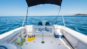A boat's deck with a table, seating, and a canopy.