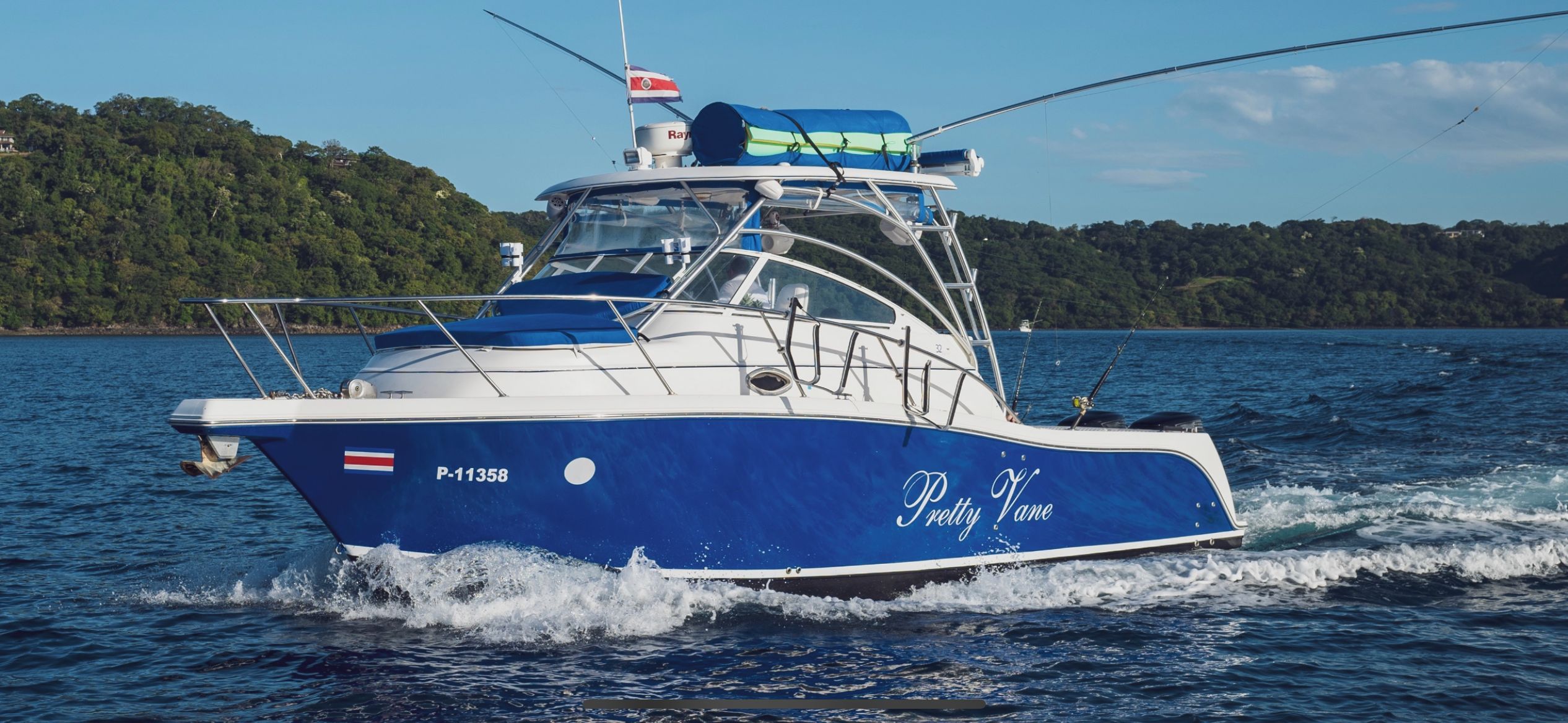 A blue and white boat named "Pretty Vane" with registration number P-11358 on a body of water.