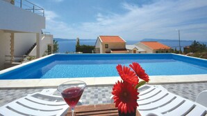 A swimming pool with a clear view of the sea and buildings in the background. - Villa Blanka - Six Bedroom Villa with Swimming Pool and Sea View (Podgora)