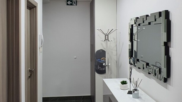 Un baño moderno con tocador, un espejo grande y una lámpara en el techo.