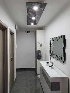 Une salle de bain moderne avec un meuble-lavabo, un grand miroir et un luminaire fixé au plafond.