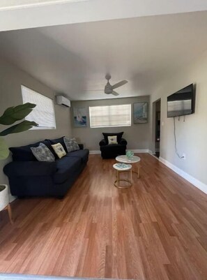Relax in this stylish living room with a sofa, coffee table, and large potted plant.