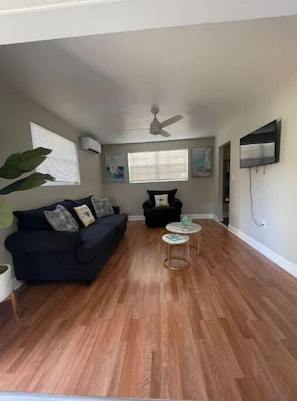 Relax in this stylish living room with a sofa, coffee table, and large potted plant.