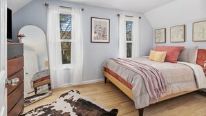 A bedroom with a bed, a dresser, a mirror, and framed artwork on the wall. - Walk to Bridge Street from the Westside Charmer! (Grand Rapids)