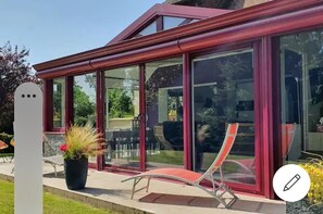 A modern house with large glass windows and a red roof.