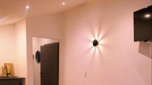 A modern living room with a sofa, a small coffee table, and a TV mounted on the wall. - Newly renovated, cozy apartment with a beautiful balcony - NEST'L Appartements (Mösern)