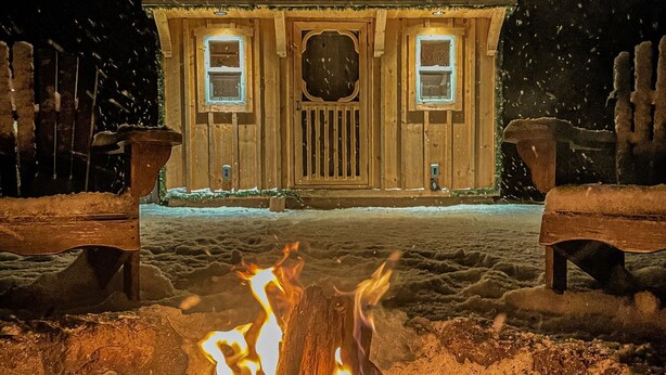 A cabin with a fire pit in front, surrounded by snow. - Boho Beaver (Grey Highlands)
