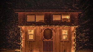 A wooden cabin with a snow-covered ground, a front door, and small windows. - Boho Beaver (Grey Highlands)