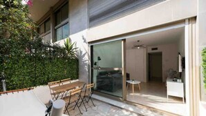 A modern outdoor patio with a wooden bench, a small round table, and a bicycle. - Nice: Superb apartment in the Carré d'Or. (Nice)