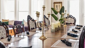 A formal dining room with a long table set for a meal, surrounded by ornate chairs and a large plant. - Family Beach Home ~Steps to Beach~Hot Tub~Game Room~Sleeps 13! (Surf City)