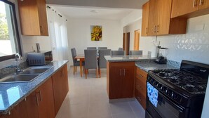 Una cucina moderna con piani in granito, un piano cottura a gas e mobili in legno.