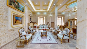A luxurious room with ornate furniture, a large chandelier, and a marble floor. - Farhyda & Frères Hôtels  (Bangangte)