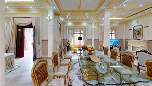 A luxurious dining room with a marble table, ornate chairs, and a chandelier. - Farhyda & Frères Hôtels  (Bangangte)