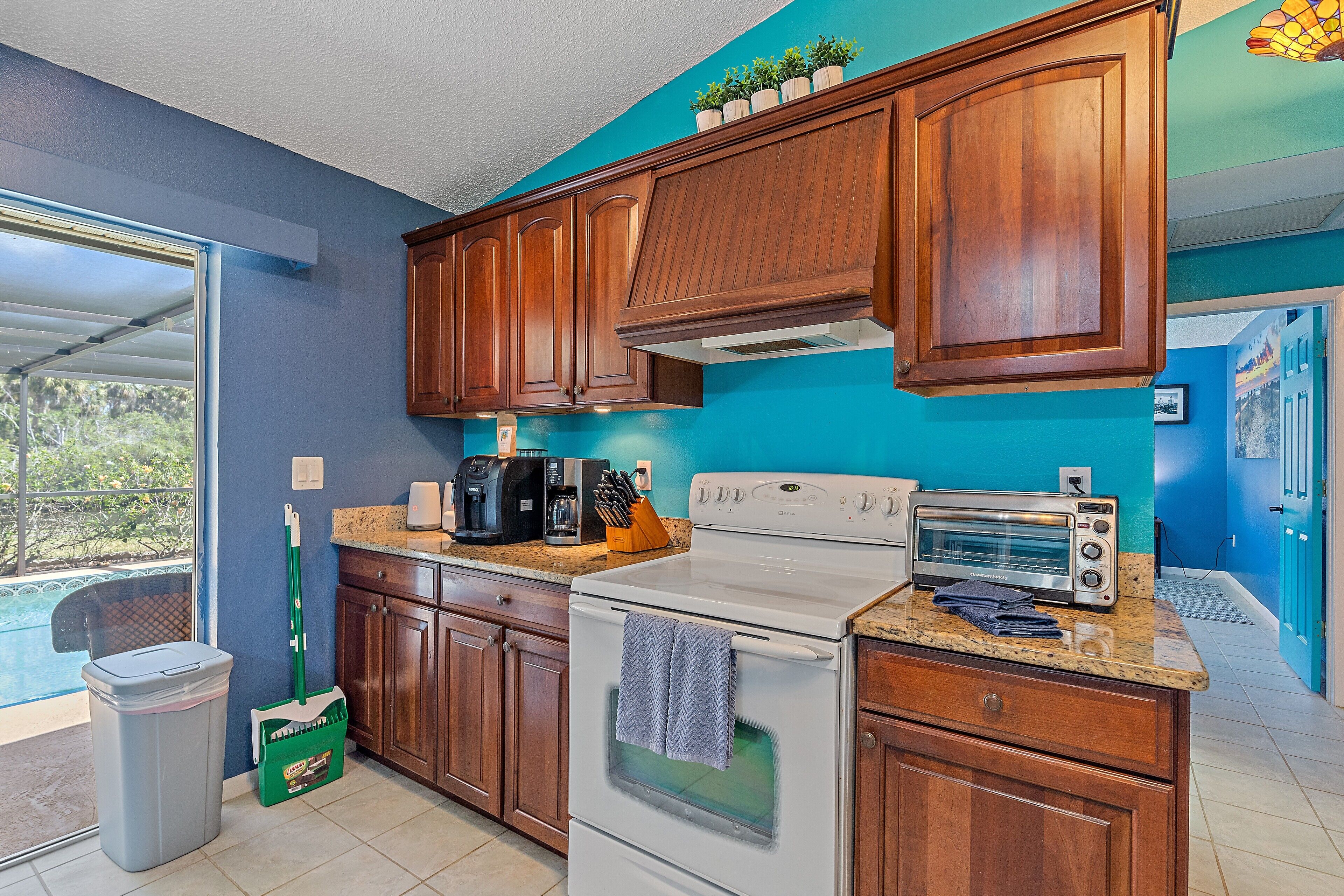 A kitchen with wooden cabinets, a white stove, a toaster, and a coffee maker.