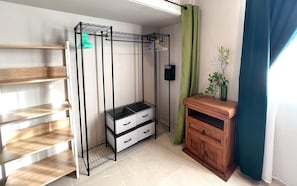 Une pièce de taille modeste, équipée d’une armoire en métal, d’un meuble en bois et d’une étagère.