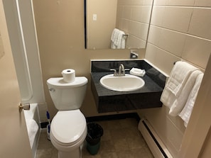 Un baño pequeño con inodoro, lavabo y espejo.