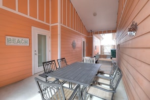 An outdoor patio with a table and chairs, a door, and a sign that reads "BEACH".
