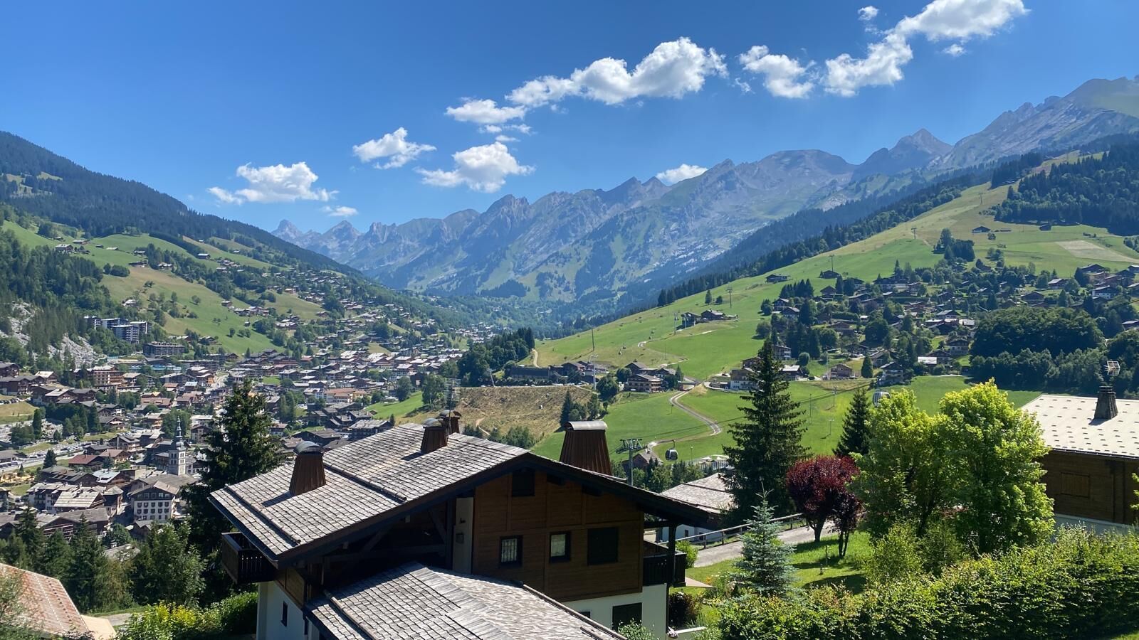 Eine Bergstadt mit traditioneller Architektur, einem zentralen Platz und Blick auf die umliegenden Hügel.