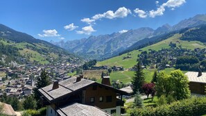 Eine Bergstadt mit traditioneller Architektur, einem zentralen Platz und Blick auf die umliegenden Hügel.