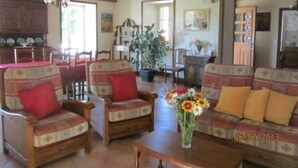 A cozy living room with wooden furniture, a dining area, and a kitchen in the background. - Le Vivier - GIVRY - Gîte (GIVRY)