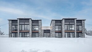 A modern two-story building with large windows and a balcony. - Modern chalet B (Gatineau)