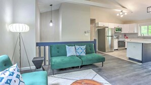A modern living room with a green sofa, a coffee table, and a floor lamp.