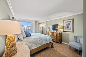 A bedroom with a bed, a dresser, a TV, and a window with a view of buildings. - N Hampton 1609 in Kingston, Oceanview, Pool, Beach (Myrtle Beach)