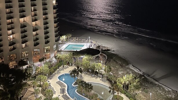 A hotel with a pool area, beachfront view, and a moonlit night. - N Hampton 1609 in Kingston, Oceanview, Pool, Beach (Myrtle Beach)