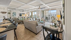 A spacious living area with a large sofa, a dining table, and a kitchen area with bar stools. - N Hampton 1609 in Kingston, Oceanview, Pool, Beach (Myrtle Beach)