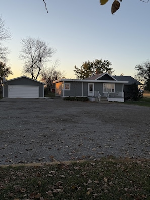 A residential property with a detached garage, a single-story house, and a gravel driveway. - Country Farmhouse (between Lethbridge & Coaldale) (Lethbridge County)