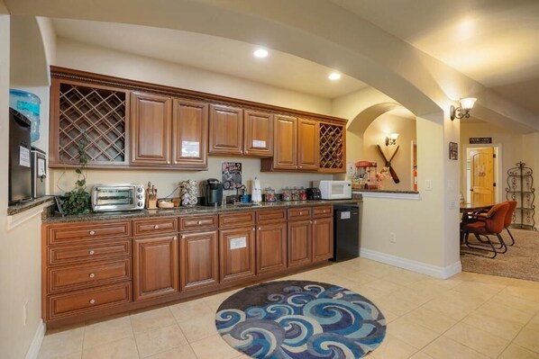A spacious kitchen with wooden cabinets, a built-in microwave, and a large island. - Summit Villa BnB (Watkins)
