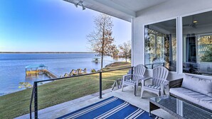 A covered outdoor area with a view of a lake, a dock, and a grassy area. - Beautiful Waterfront Getaway w/ Dock! (Abbeville)